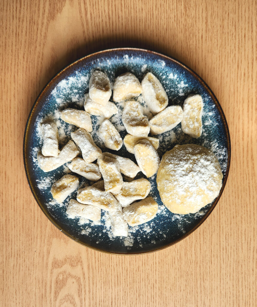 Raw gnocchi dough on a plate, dusted with flour