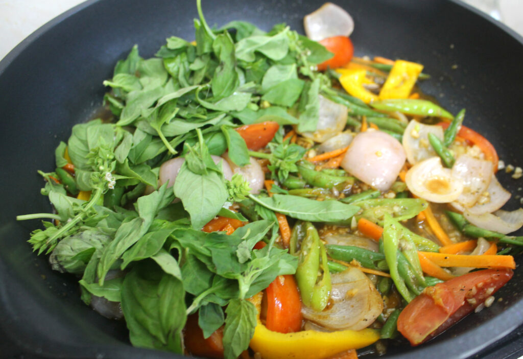 ingredients for chilli basil stir fry in a pan with sauce