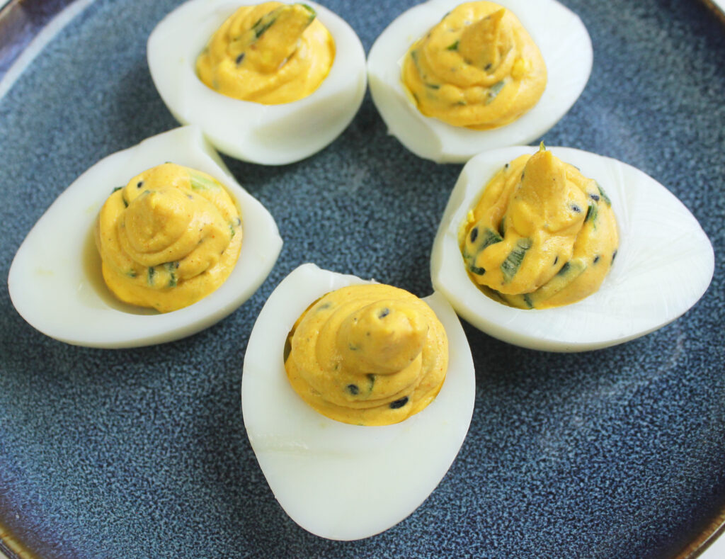 5 pieces of Gochujang devilled eggs arranged on a plate