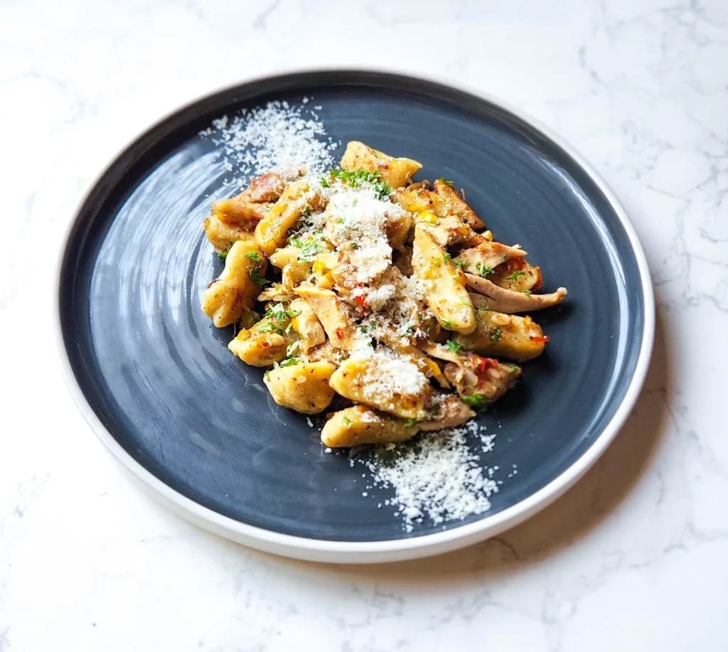 Gnocchi Aglio e Olio on a plate with shaved parmesan and parsley 