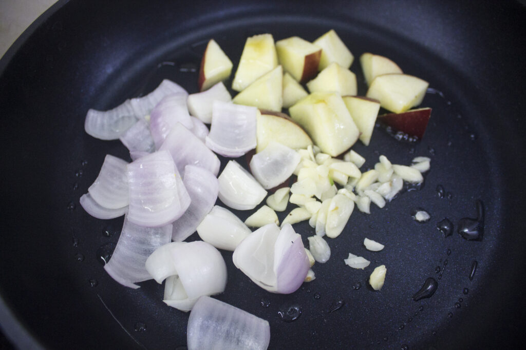 onions, garlic and chopped apples in a pan with oil