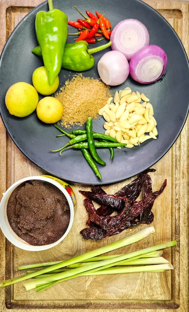 Indonesian sambal terasi ingredients lemongrass, onions, garlic, palm sugar, red chilli, green chilli, lime, dried red peppers and fermented shrimp paste