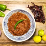 Indonesian sambal terasi in a bowl with ingredients lemongrass, onions, lime, dried red peppers