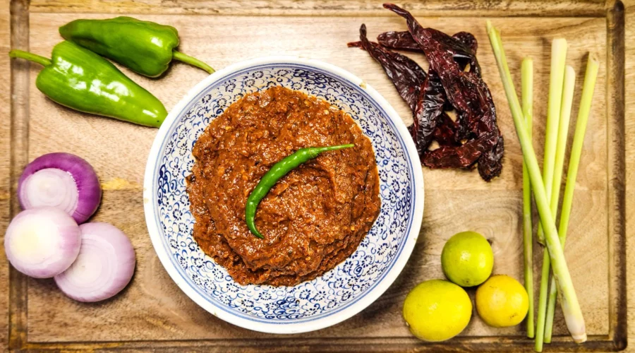 Indonesian sambal terasi in a bowl with ingredients lemongrass, onions, lime, dried red peppers