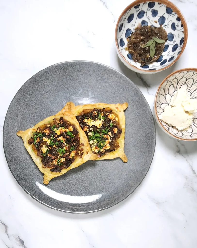 Caramelised onion galette pastry with roasted pumpkin and goat's cheese on a plate