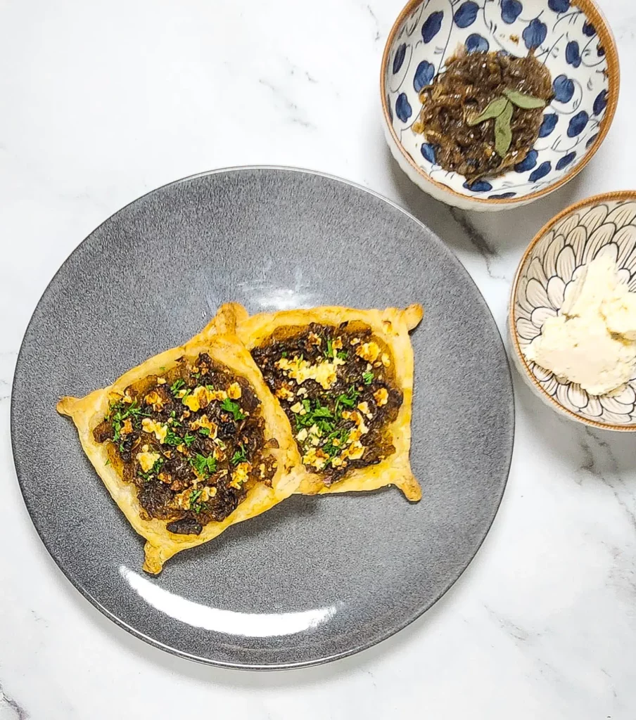 Caramelised onion galettes pastry with roasted pumpkin and goat's cheese on a plate