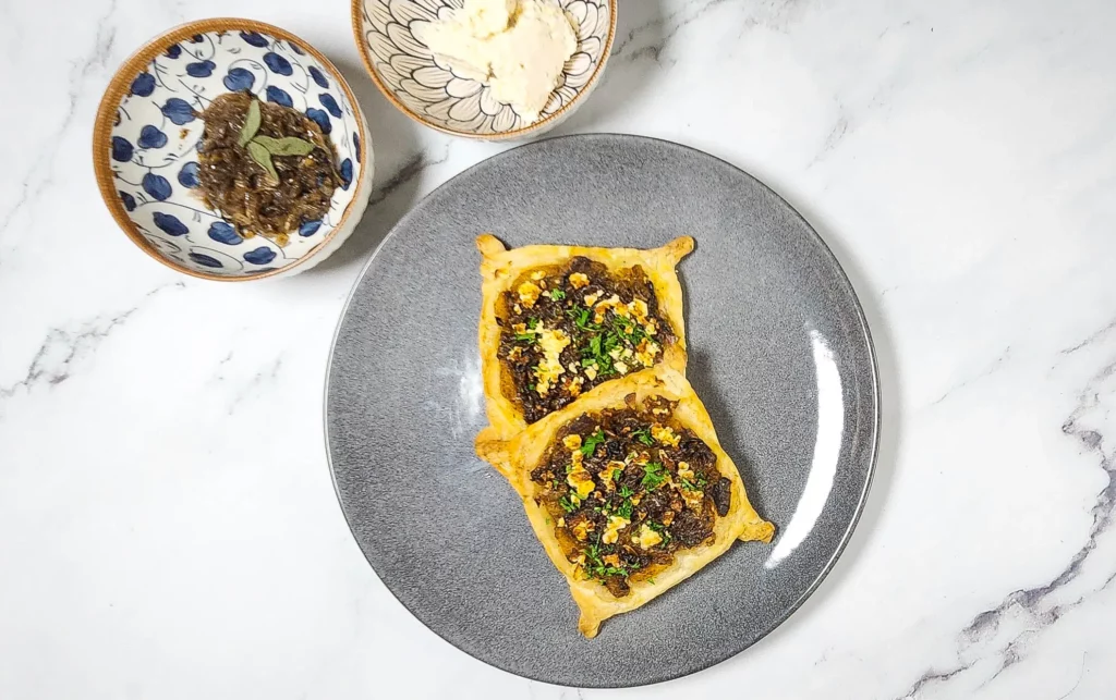 Caramelised onion galette pastry with roasted pumpkin and goat's cheese on a plate