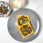 Caramelised onion galette pastry with roasted pumpkin and goat's cheese on a plate