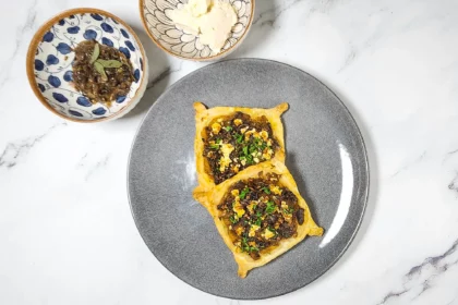 Caramelised onion galette pastry with roasted pumpkin and goat's cheese on a plate