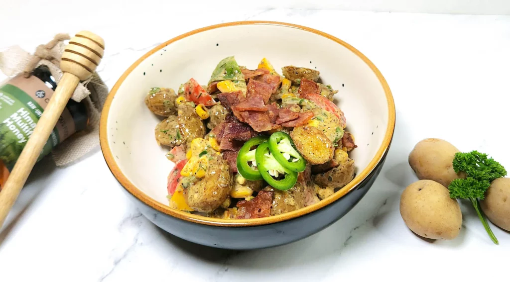 Japanese-fusion potato salad with bacon, vegetables and mustard, mayonnaise dressing in a bowl. baby potatoes, parsley and honey.