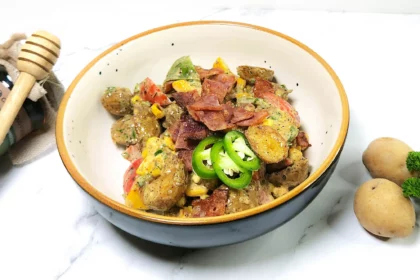 Japanese-fusion potato salad with bacon, vegetables and mustard, mayonnaise dressing in a bowl. baby potatoes, parsley and honey.