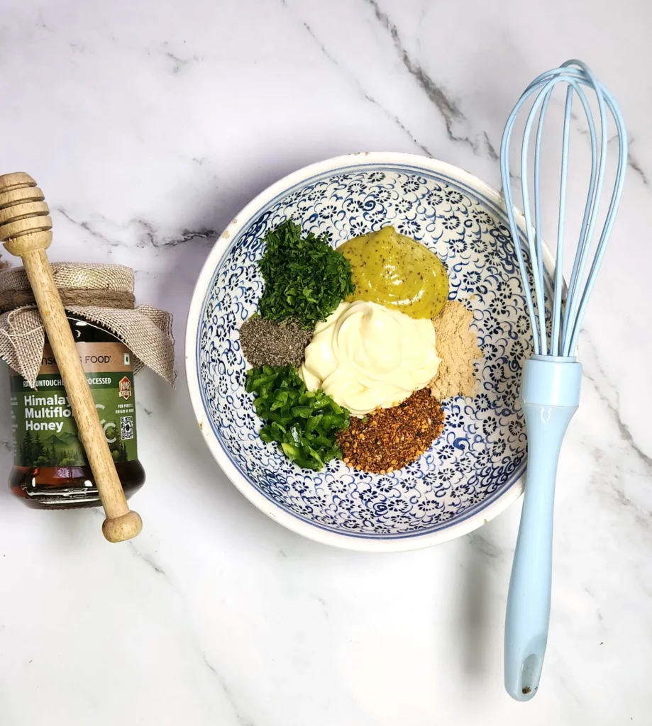 Japanese-fusion potato salad dressing ingredients in a bowl - mustard, Kewpie mayonnaise, honey, toasted sesame oil, parsley, jalapenos, salt, pepper