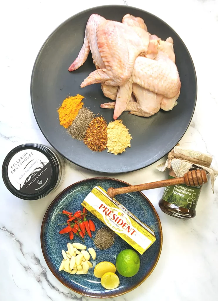 dry rub chicken wing ingredients including wings, pepper, garlic powder, Japanese chilli powder, turmeric powder and salt. Sweet chilli sauce ingredients including honey, butter, pepper, salt, lime garlic, and chillis