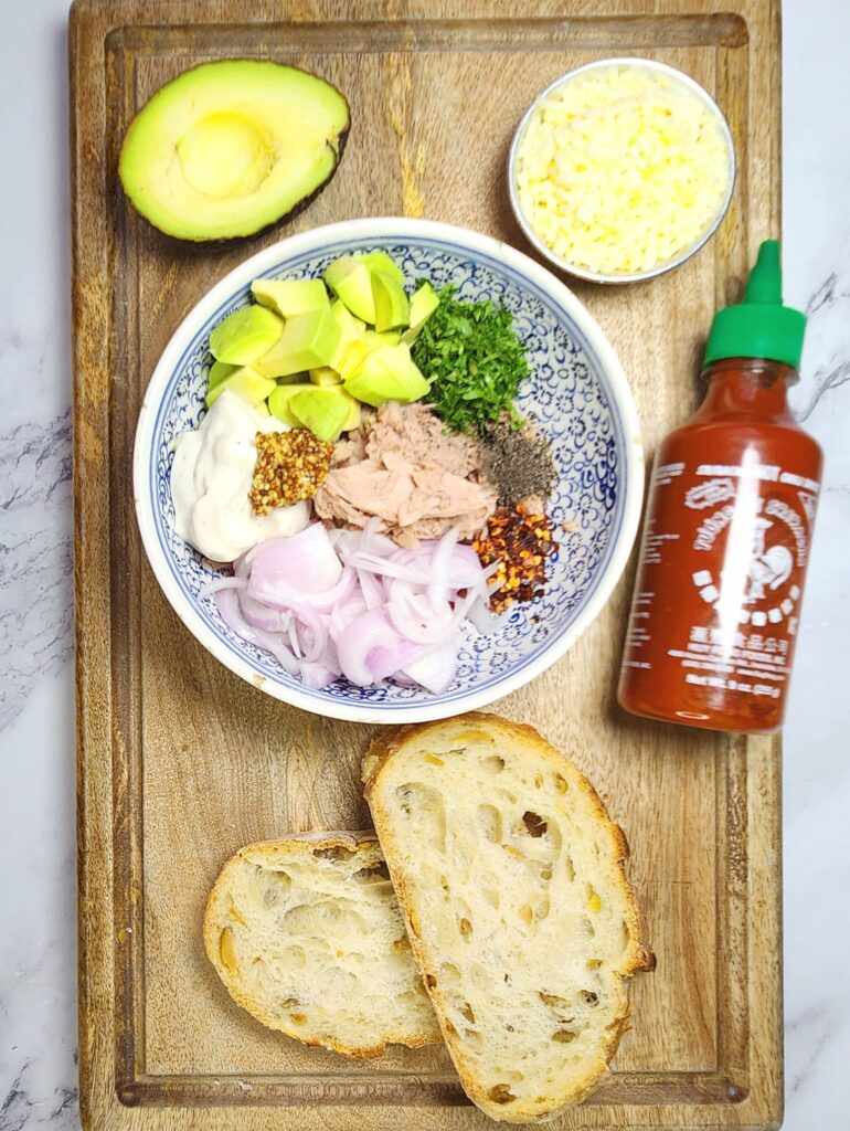 tuna melt mix with onions, mayo, cheese and avocado, sourdough slices, sriracha sauce