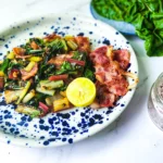 Sauteed Swiss chard with bacon on a plate with lime and salt