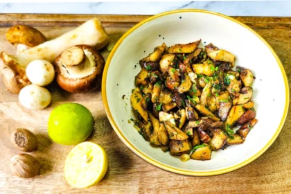 Garlic Butter Mushrooms in a plate with parsley on top, assorted mushrooms, lime and nutmeg