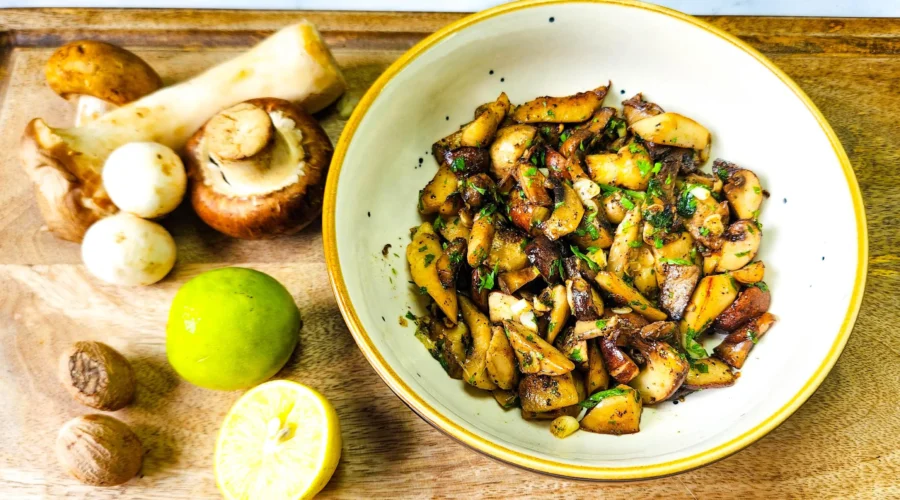 Garlic Butter Mushrooms in a plate with parsley on top, assorted mushrooms, lime and nutmeg