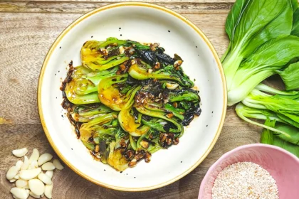 easy stir fried bok choy with hoisin sauce in a bowl with garlic, sesame seeds and baby bok choy