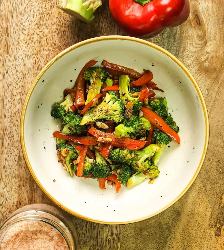 chargrilled broccoli and peppers in a bowl with black pepper, salt