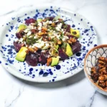 beetroot salad with goats cheese and candied walnuts in a plate with leeks and avocado