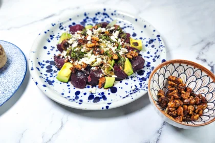 beetroot salad with goats cheese and candied walnuts in a plate with leeks and avocado