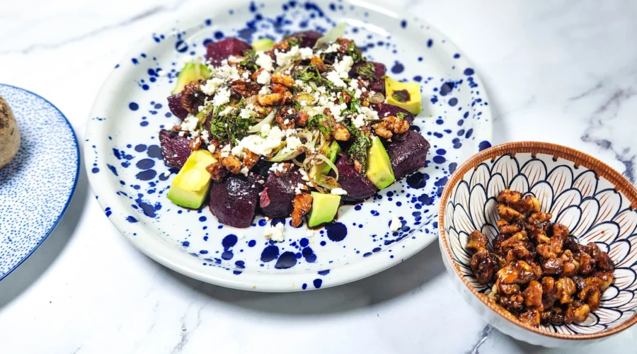 beetroot salad with goats cheese and candied walnuts in a plate with leeks and avocado