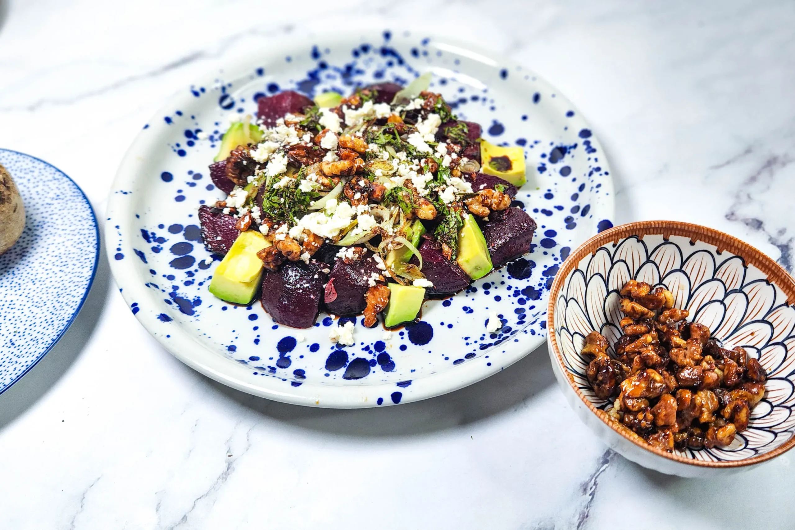 beetroot and feta salad with candied walnuts and balsamic glaze in a plate with leeks and avocado