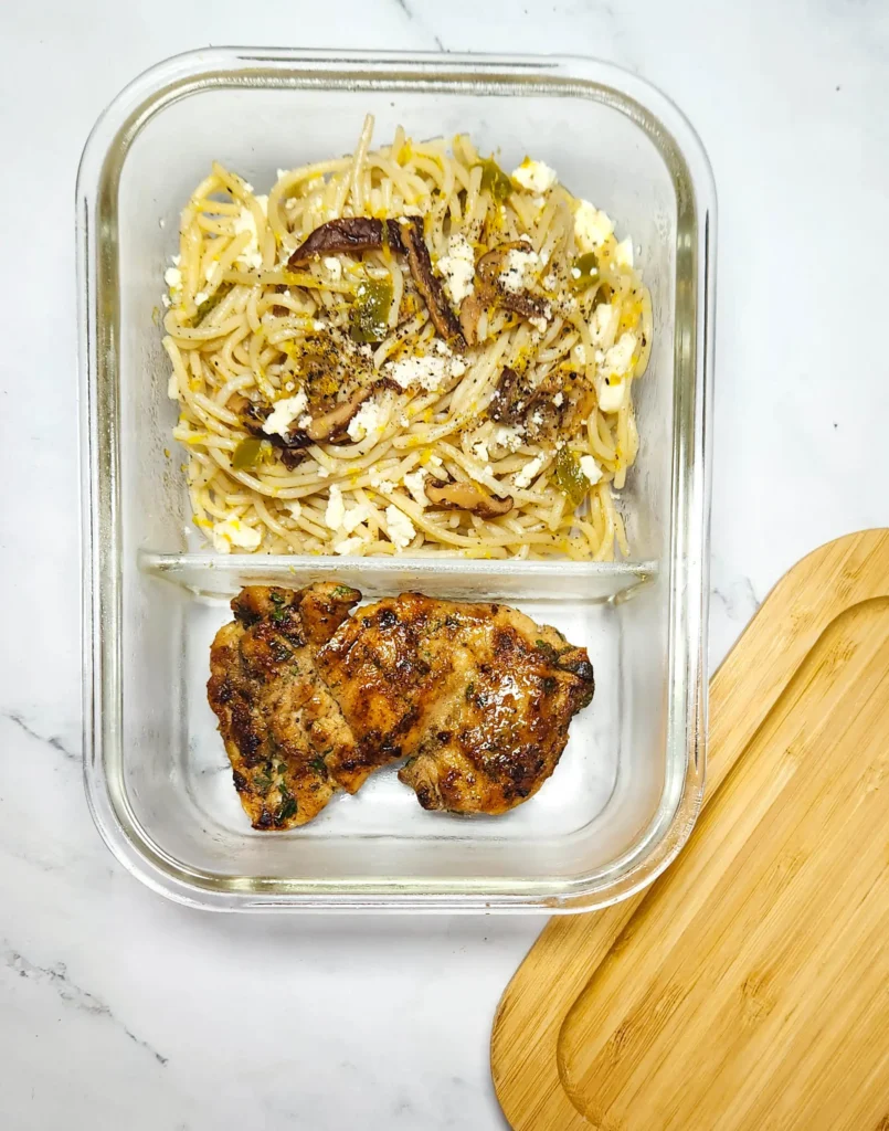 lemon butter linguine in a lunchbox with lemons, goat's cheese and shiitake mushrooms, peppers and grilled chicken