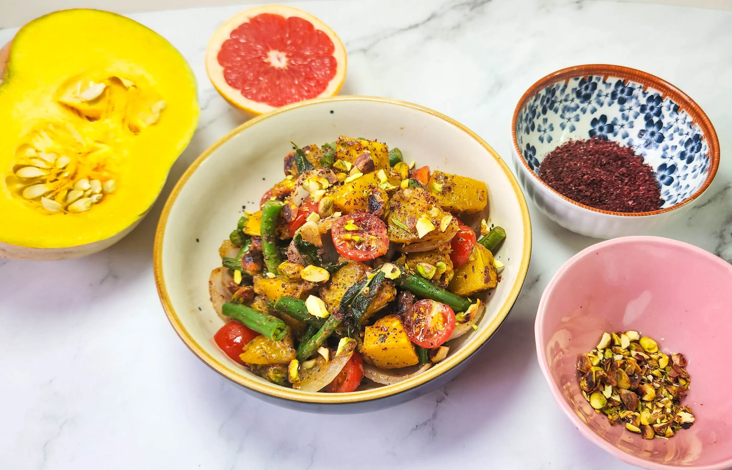 Roasted pumpkin salad in a lunchbox with cherry tomatoes, pistachios, beans, onions, pumpkin, butter, garlic and sage leaves. Sumac, mustard sauce, lime, honey and grapefruit dressing. Grilled prawns and lime.