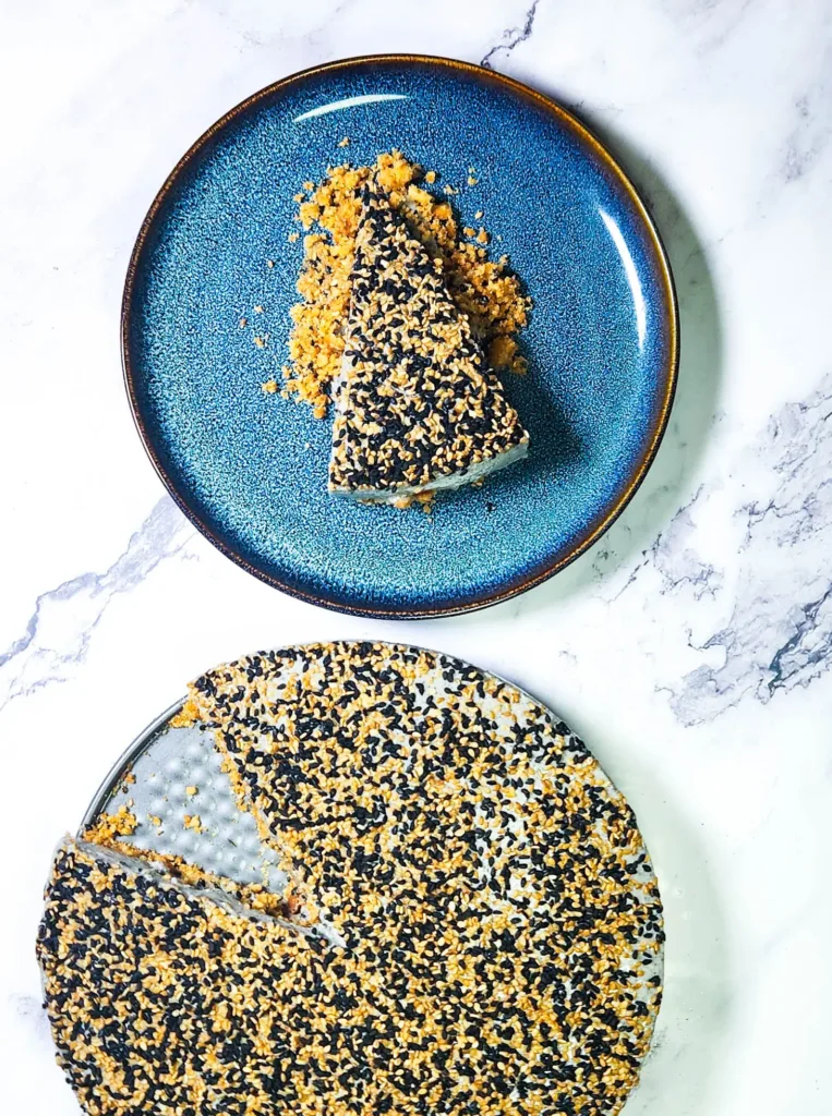 black sesame cheesecake slice on plate and whole cake