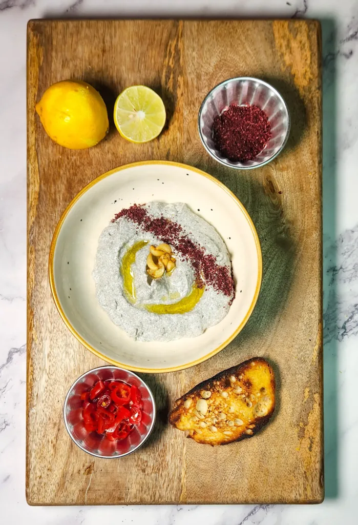 Black Sesame Labneh Dip Recipe final photo with confit garlic, toast, sumac, lemon and pickled peppers